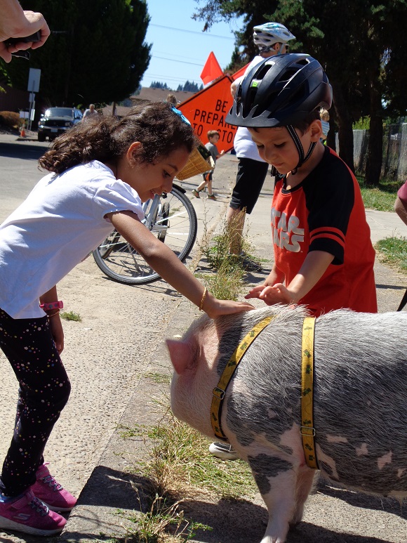 Children petting a large pig.